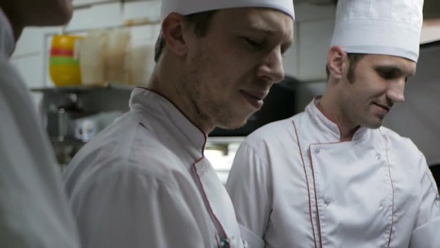 Chefs preparing a dish in a commercial kitchen
