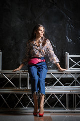 Fototapeta premium Beautiful girl in shirt with flower print, short wide jeans and pink leather waist bag posing
