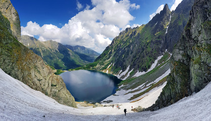 Fototapeta premium Morskie Oko. Wysokie Tatry, Polska, 27 maja 2018 r. Piękny krajobraz ośnieżonych szczytów górskich i jeziora między nimi.