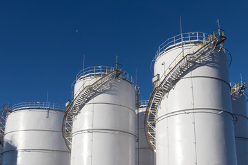 Large white Industrial tanks for petrol and oil.
