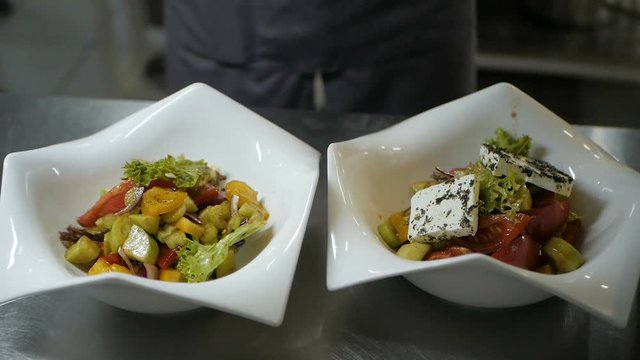 Chef puts Greek salad on a dish in the restaurant