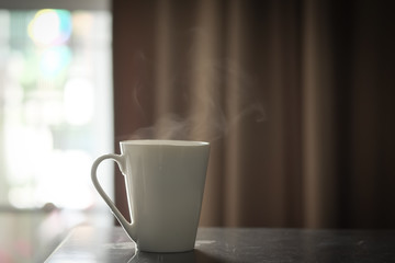 Hot coffee in white cup on a wooden table at morning