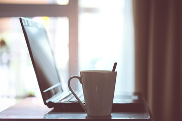 Hot coffee in white cup on a wooden table at morning