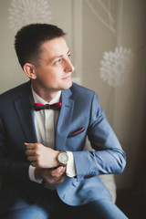 Young handsome man relaxing at his apartment in a hotel after business meeting