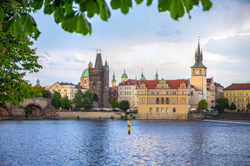 Naklejka premium Evening view of Charles Bridge and Lesser Bridge Tower in Prague, Czech Republic