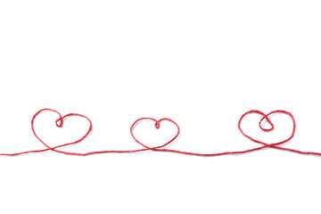 Red thread and three hearts isolated on white background