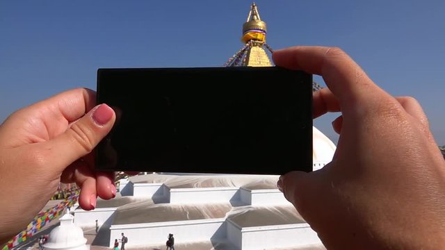 Taking Photos with Mobile Phone of Buddhist Stupa Boudhanath in Kathmandu, Nepal