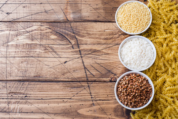 Dry groats grocery. Rice pasta buckwheat and millet on the wooden background.