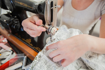 Female Tailor Using Retro Sewing Machine At Home