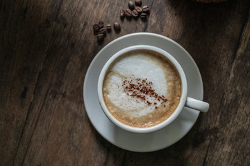 A cup of coffee in the wooden table.