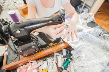 Female Tailor Using Retro Sewing Machine At Home