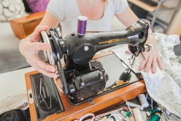 Fototapeta premium Female Tailor Using Retro Sewing Machine At Home