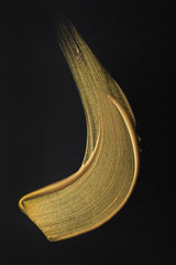 Stroke of gold paint on dark background