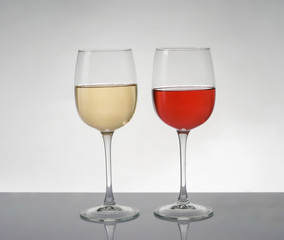 Glasses of expensive red and white wines on table