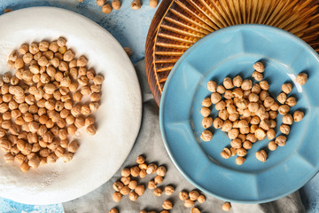 Plates with dry chickpeas on table