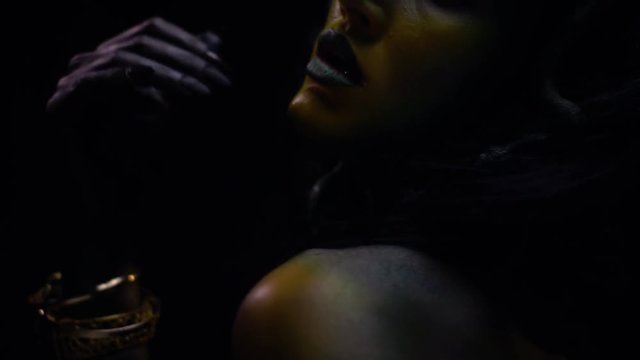 Woman with colorful make up and body art waving her hand
