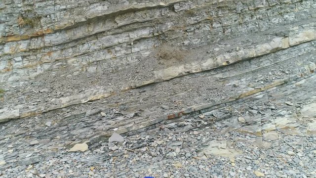 Woman is doing yoga and physical exercises on rock and sea background. Aerial beautiful footage view.