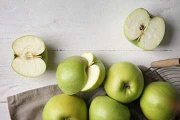 Whole and cut tasty apples on wooden table