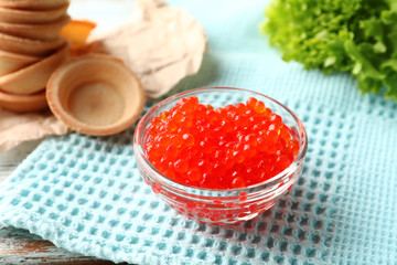 Bowl with tasty red caviar on table