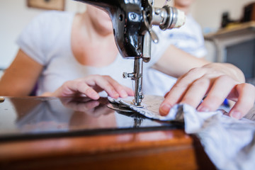Female Tailor Using Retro Sewing Machine At Home