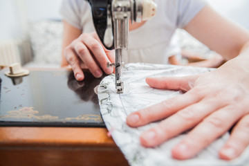 Female Tailor Using Retro Sewing Machine At Home