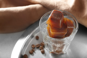 Glass with coffee ice cubes on table
