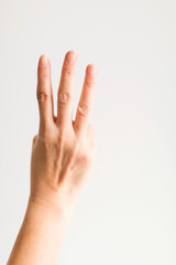 A hand showing three fingers for counting three.