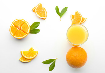 Frame made of sliced oranges and glass of juice on white background
