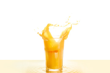 Glass of orange juice with splash on white background