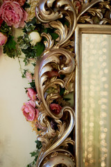 Massive silver mirror frame on floral wall background. Decor photo zone, Banquet