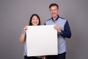 Portrait of multi ethnic diverse couple in studio showing copy space