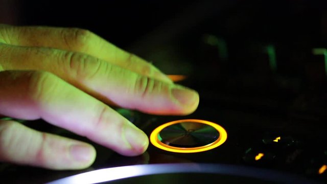 Deejay sta lavorando alla sua consolle mettendo musica per la folla che balla in un locale notturno