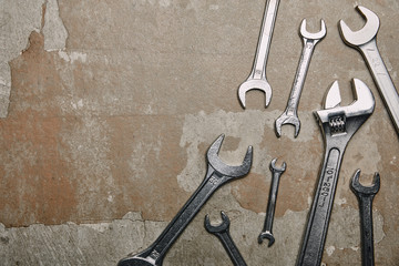 Top view of different wrenches and one monkey wrench on the background of old  surface