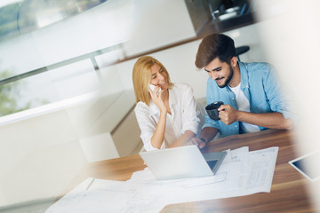 Obraz premium Handsome young man and attractive woman working on laptop