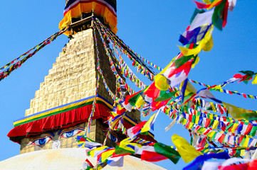 Buddha eyes close up with prayer flags at Bodhnath stupa in Kathmandu valley, Nepal