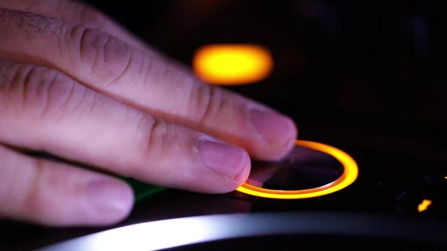 Deejay sta lavorando alla sua consolle mettendo musica per la folla che balla in un locale notturno