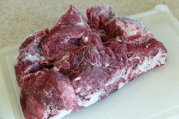 frozen beef in refrigerator, left to thaw,