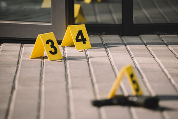 blured close up view of crime scene with gun and numbers