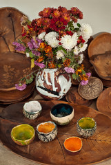 Clay pottery and ceramic products on a wooden table. Home workshop. Handmade with drawings and patterns.
