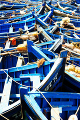 Fototapeta na wymiar Fishing blue boats in Marocco. Lots of blue fishing boats in the port of Essaouira, Morocco