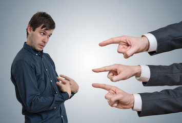 Young employee get fired. Many hands are blaming him.