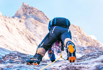 Climber reaches the summit of mountain peak. Climbing and mountaineering sport concept