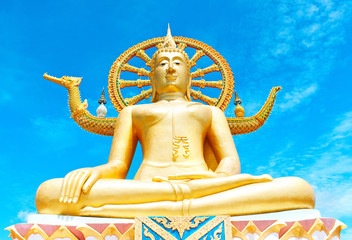 Big gold Statue of Buddha in Thailand on a background of blue sky