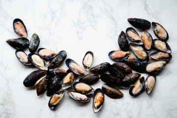 Top view with frozen mussels on white marble background layed in frame shape with a space for text