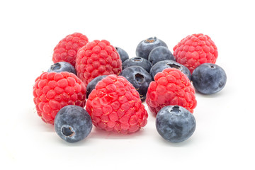 A mixture of raspberries and blueberries against a white background
