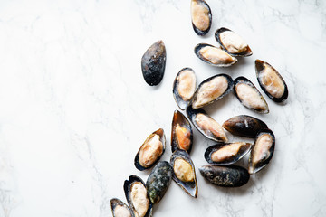 Top view with frozen mussels on white marble background with copy space