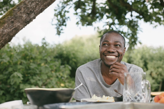 Smiling Man Looking Away Having Lunch At Table