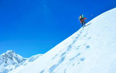 Naklejka na ściany i meble A climber reaching the summit of the mountain. Active sport concept