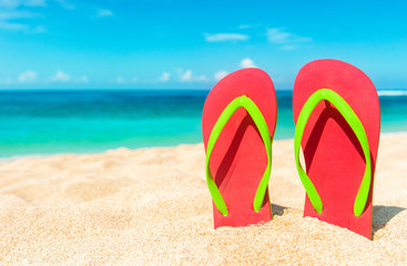 Fototapeta na wymiar Beach sandals on the sandy coast. Summer holiday and vacation concept.