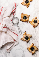 Fototapeta na wymiar Scandinavian pastry Joulutorttu is traditional finnish and Swedish christmas pastry. It is traditionally made from puff pastry in the shape of a star or pinwheel and filled with prune jam and often du
